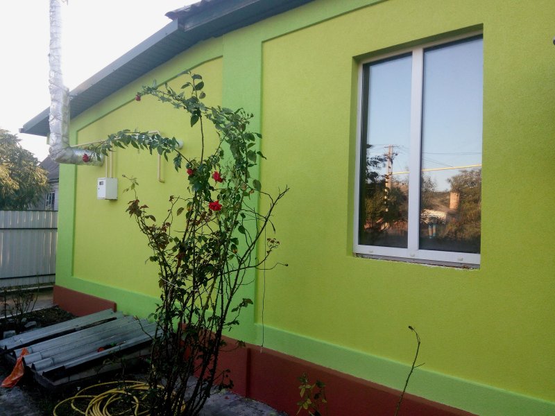 Бригада специалистов выполняет работы по утеплению фасада дома